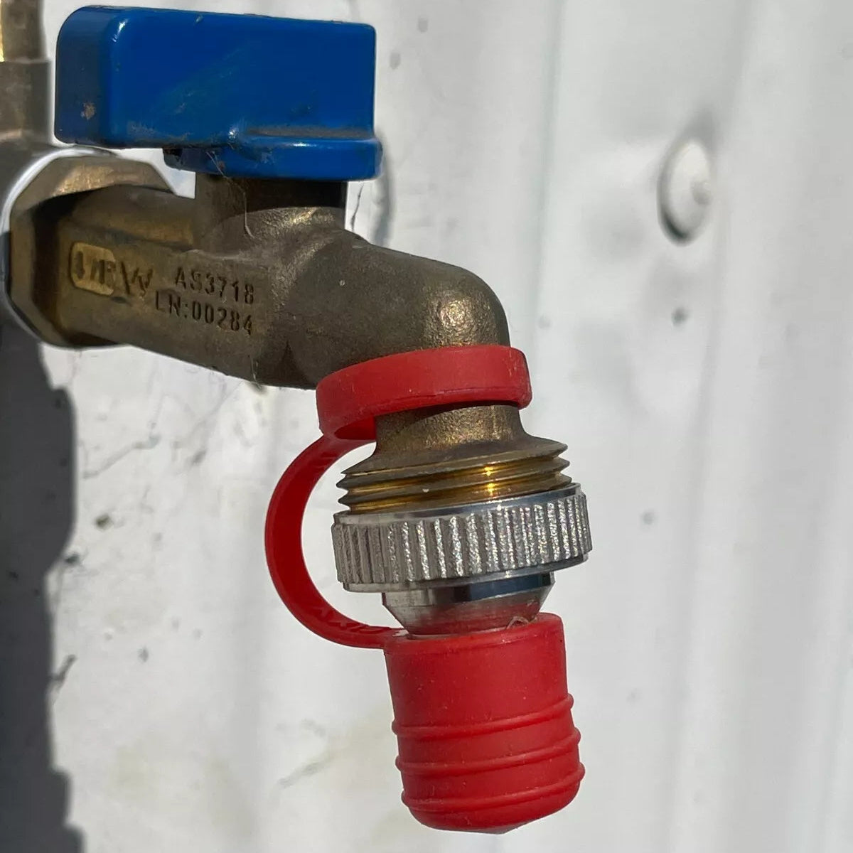 Metal valve with red fitting on a white background
